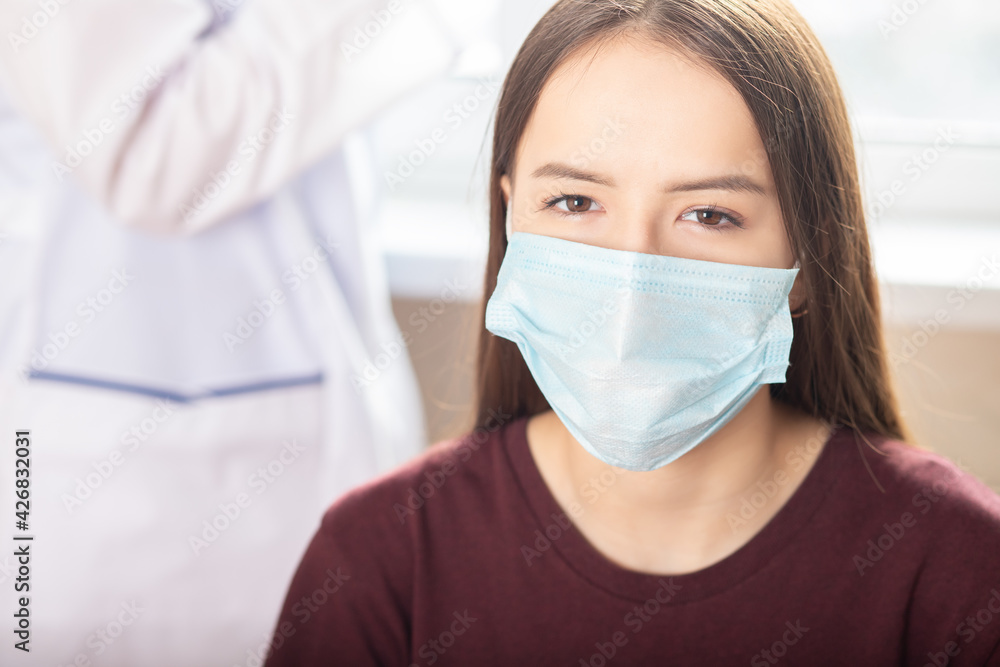 young teen girl at the doctor's appointment at the medical clinic wearing protective mask
