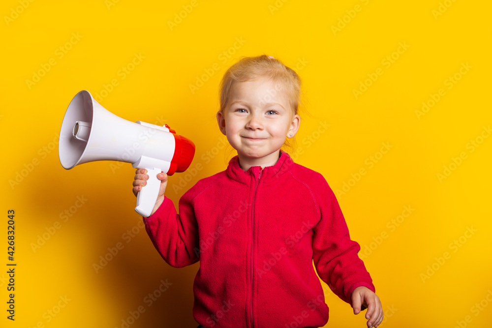 © Alex - smiling child girl holding a megaphone on a bright yellow background. © Alex - smiling child girl holding a megaphone on a bright yellow background.