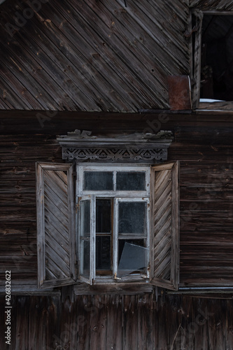 The window of an old wooden house. A window with shutters..