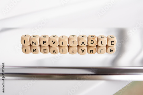 Word inevitable by wooden cubes