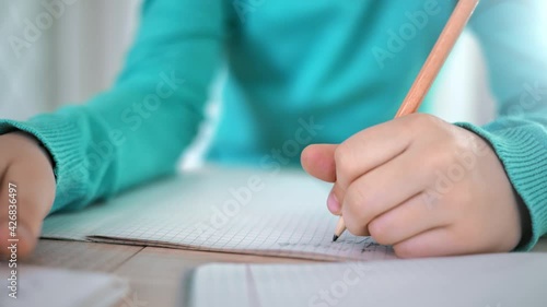 Closeup school pupil male writing letter on paper notebook. Shot on RED Raven 4k Cinema Camera