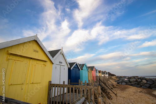 A row of colourful beach huts on the coast of Suffolk, UK