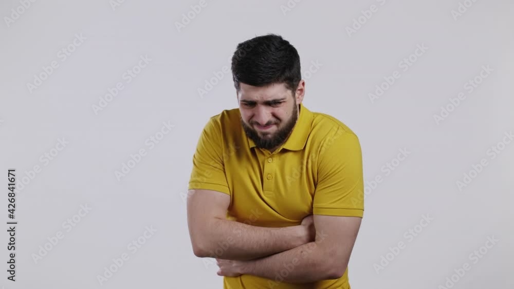 Man squeezing belly with hands because of abdominal pain. Guy suffering from stomach ache. Healthcare, problem with bowel flatulence concept Man squeezing belly with hands because of abdominal pain. Guy suffering from stomach ache. Healthcare, problem with bowel flatulence concept