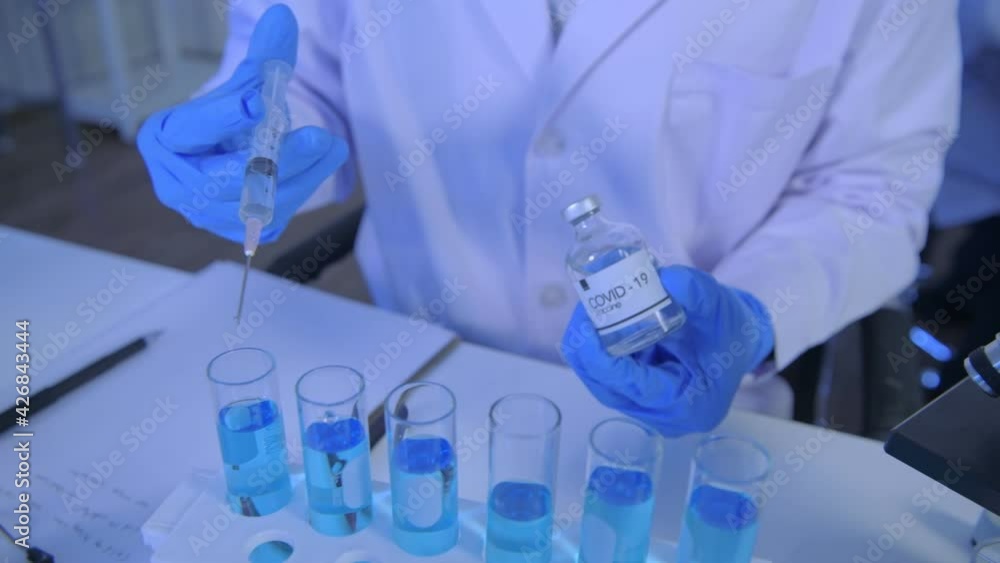 Research concept of 4k resolution. Scientists are dropping the vaccine into a test tube. Research concept of 4k resolution. Scientists are dropping the vaccine into a test tube.