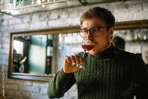 Man tasting cocktail based on gin, vermouth and mushrooms. 