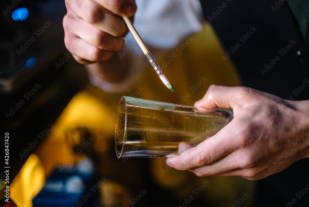 Bartender decorating glass with wasabi icing. Bartender decorating glass with wasabi icing.