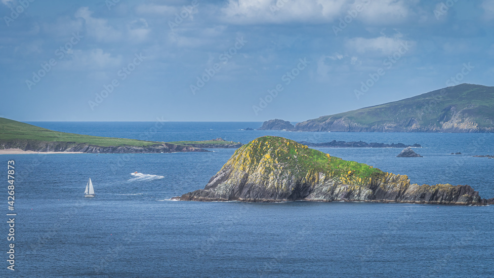 Sailboat and motorboat sailing between small rocky islands in Dingle Peninsula, seen from Slea Head, Wild Atlantic Way, Kerry, Ireland