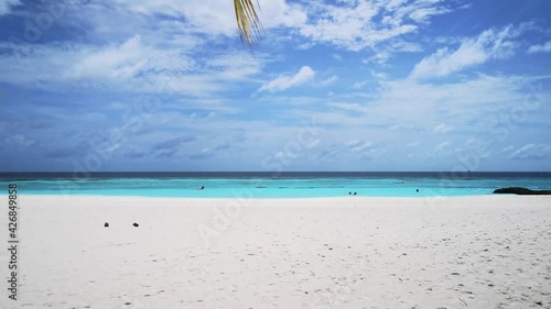 Walking under a palm tree to the beautiful paradise beach on Thulhagiri Island, Maldives photo
