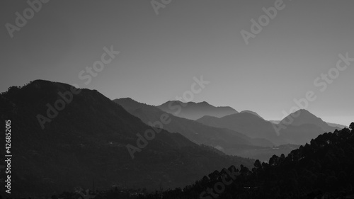 A panoramic landscape view of mountain ranges silhouette in black and white