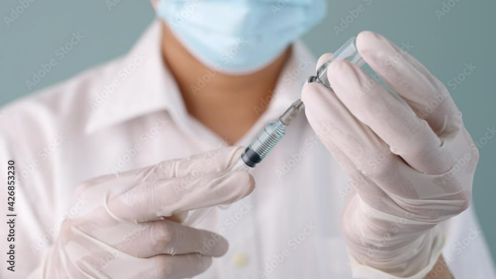 Close up of hand doctor or nurse holding syringe and bottle vaccine or inject. health drug covid or influenza concept Close up of hand doctor or nurse holding syringe and bottle vaccine or inject. health drug covid or influenza concept