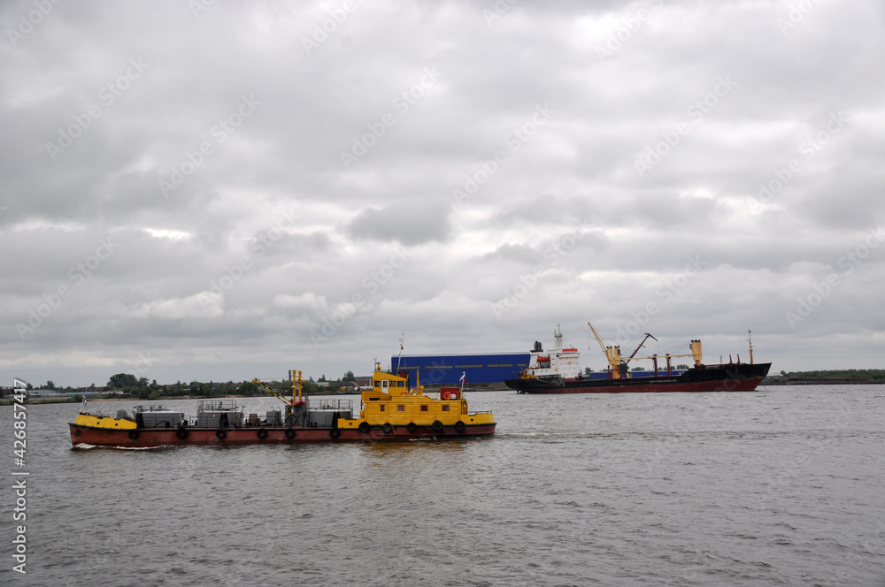 Panoramic view of the Volga river with passing ships on a cloudy day.