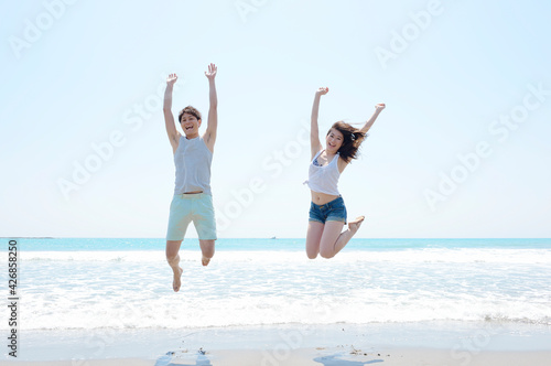 海でジャンプするカップル