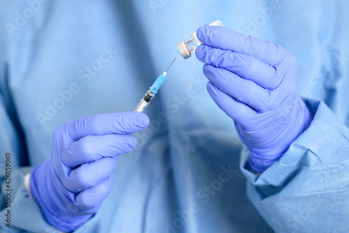 Doctor holding a syringe with a single bottle vial of Covid-19 vaccine. Concept fight against virus. Close up detail. Medical concept vaccination hypodermic injection treatment. High quality photo