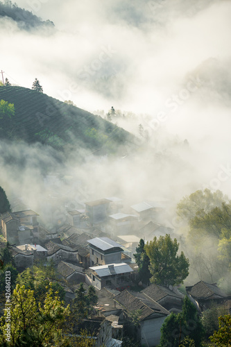 A small village in the cloud sea under sunrise.