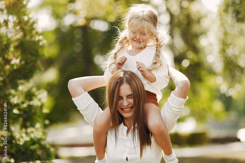 Naklejka premium Mother with little daughter playing in a summer park