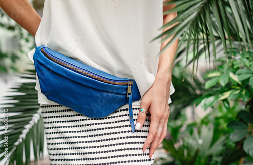 Blue belt bag on model. Fashionable accessory.