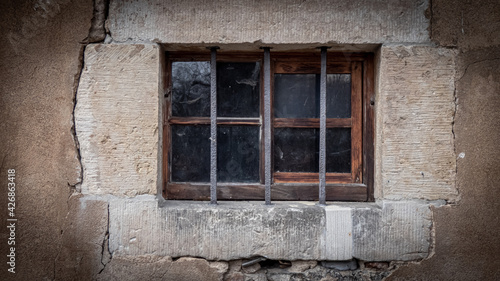 Altes Holzfenster mit Gitterstäben in einem Gemäuer