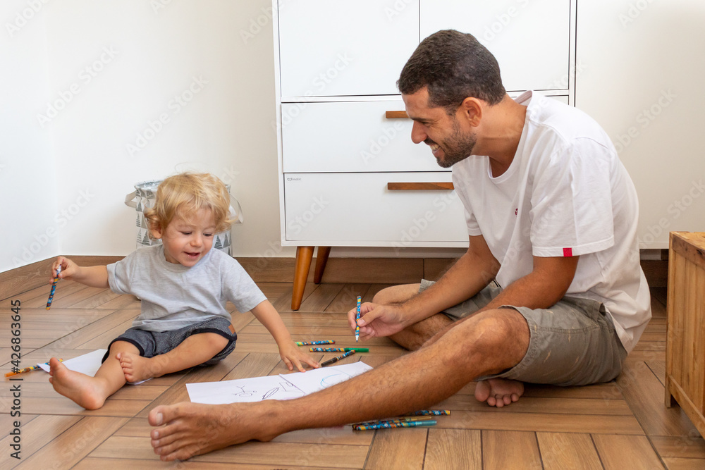 PAI E FILHO DESENHANDO JUNTOS NO CHÃO. PAI E FILHO DESENHANDO JUNTOS NO CHÃO.