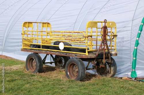 Alter gelber Anhänger zum Transportieren von Material auf einer Wiese photo