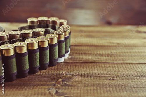 bandolier with rifle cartridges on wooden background 