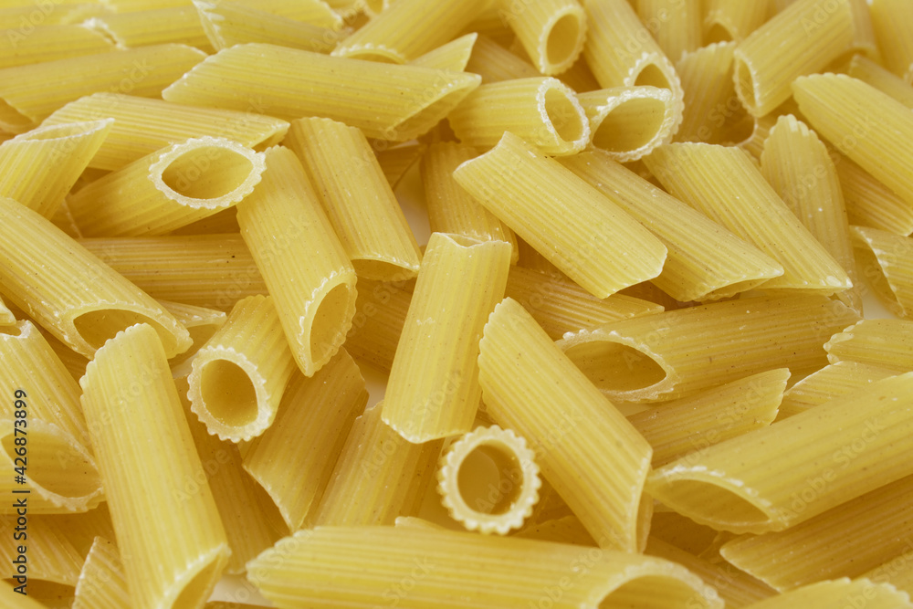 Texture with raw penne pasta. Uncooked Italian food ingredient Texture with raw penne pasta. Uncooked Italian food ingredient