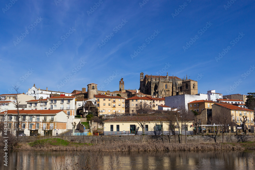 Plasencia city skyline with the Jerte river in the foreground and the cathedral and other historic buildings in the background