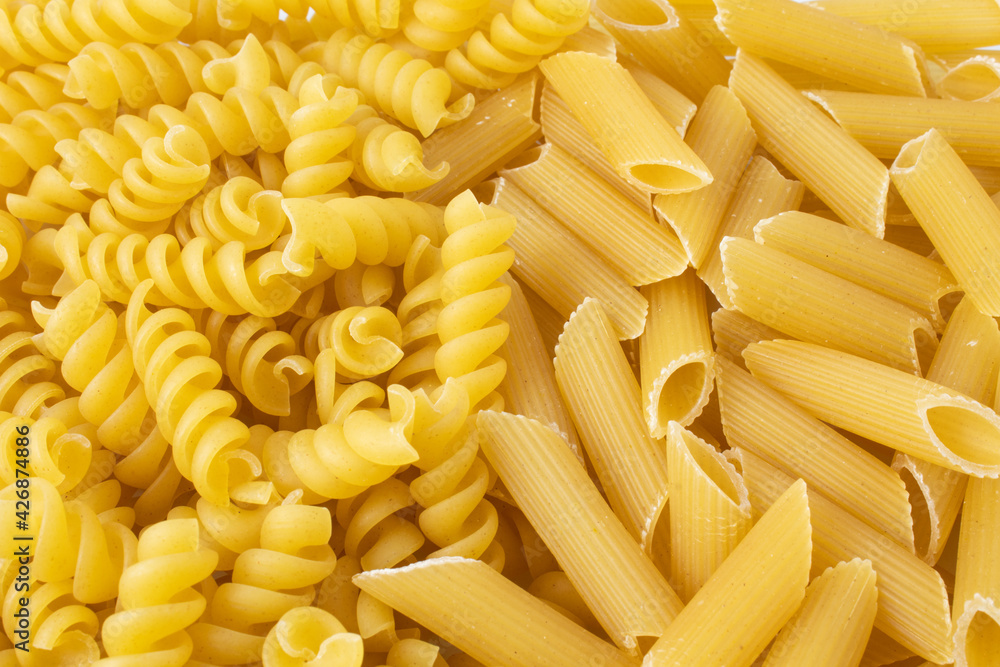Texture with raw fusilli and penne pasta Texture with raw fusilli and penne pasta