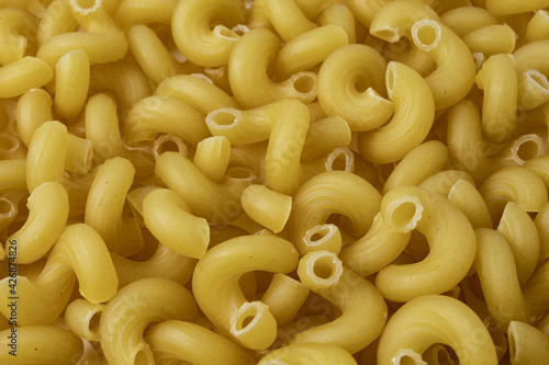 Texture with raw cavatappi or cellentani pasta. Mac and cheese noodles.