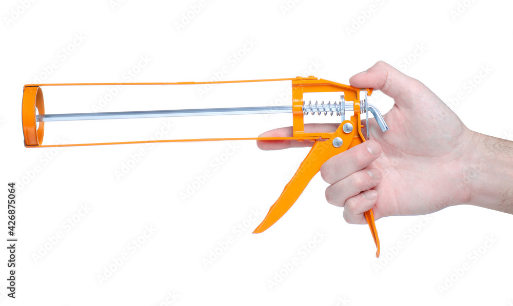 Orange silicone gun in hand on white background isolation Orange silicone gun in hand on white background isolation