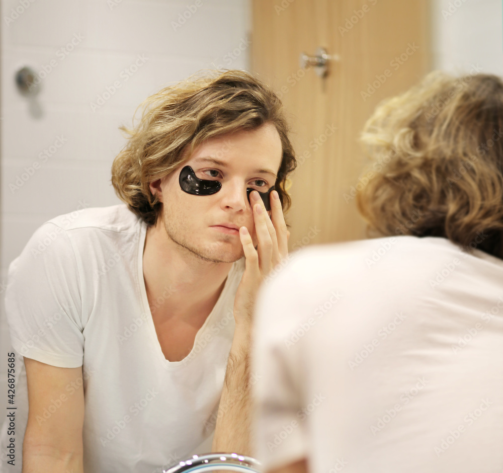 young man applying facial mask. Dark Circles.Eye patches.. young man applying facial mask. Dark Circles.Eye patches..