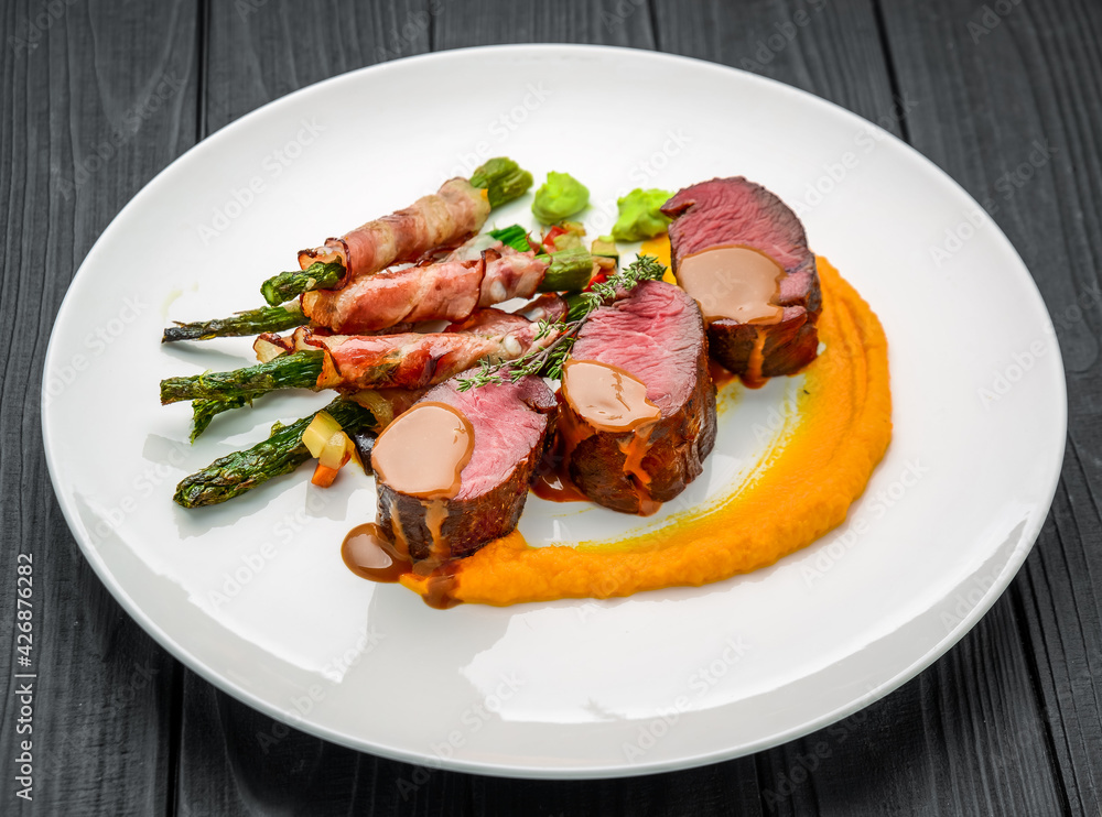 Grilled veal tenderloin with salad, with asparagus and bacon