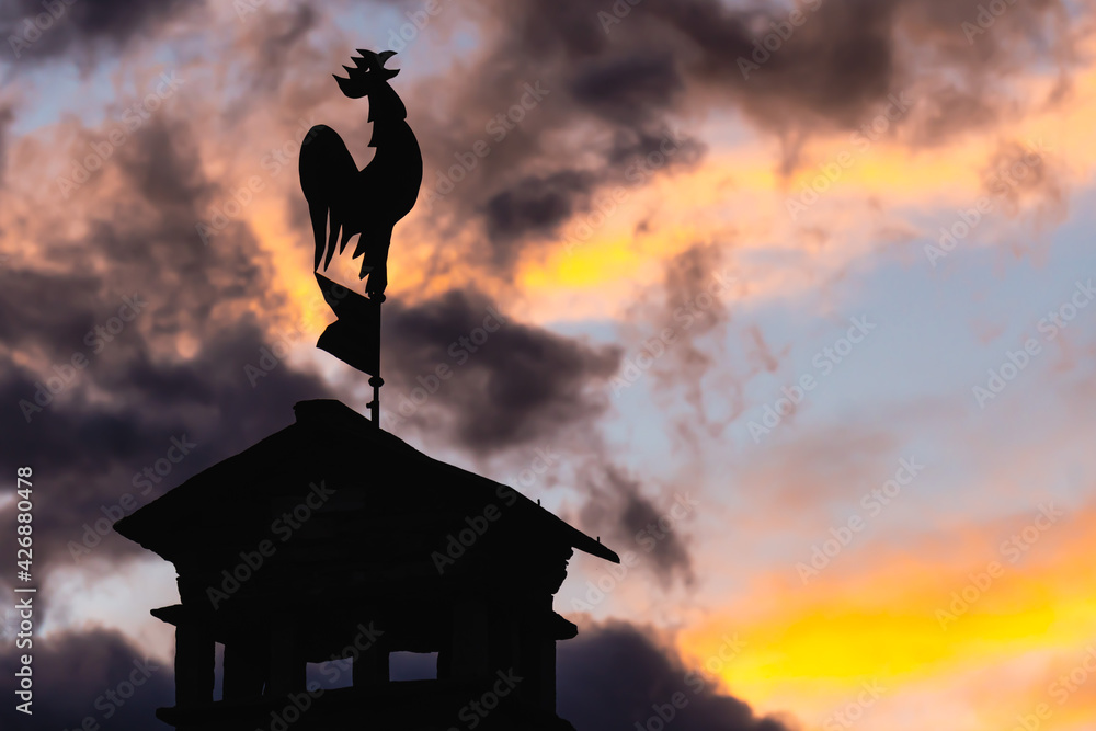 scena con un galletto sul tetto della casa al tramonto. sveglia. scena  all'alba con un gallo sul tetto. buongiorno. mattina presto. Stock-foto |  Adobe Stock