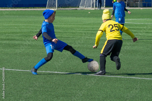 Children's football. Children are playing football. The active struggle and dynamics of the boys' soccer match. The boys are recklessly fighting for the ball photo