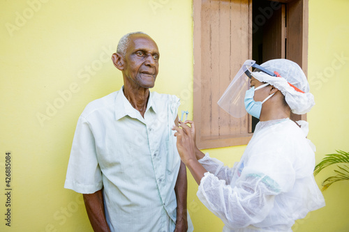 Homem idoso brasileiro é vacinado contra Covid 19, em área rural de Guarani, Minas Gerais, Brasil photo