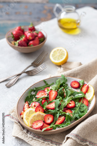 Healthy organic diet salad with arugula, strawberries and almonds.