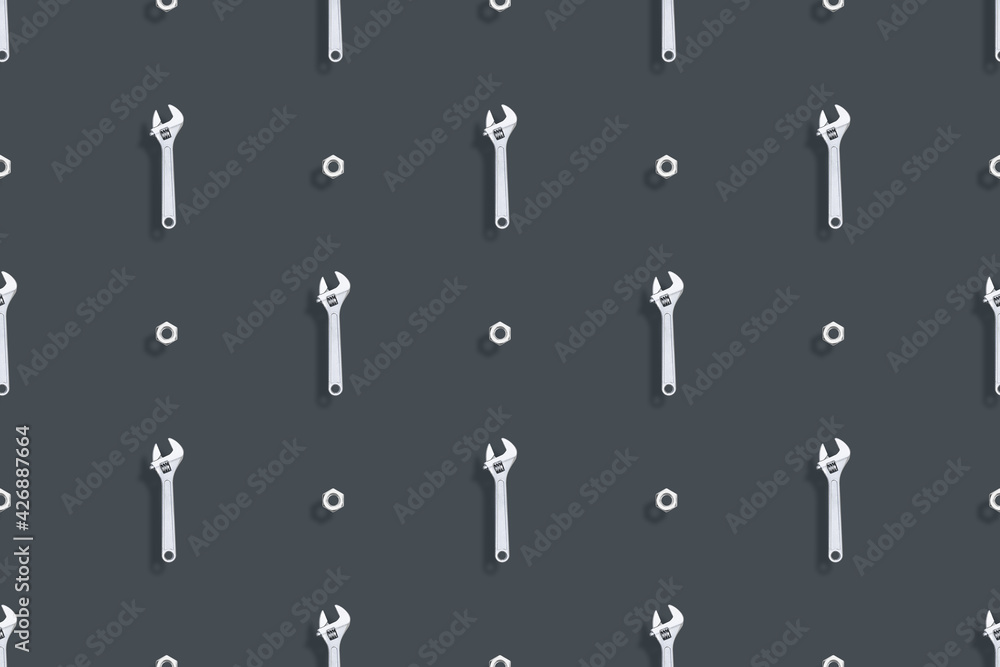 Adjustable metal wrench seamless pattern. Background from a metal wrench and nut. Adjustable metal wrench seamless pattern. Background from a metal wrench and nut.
