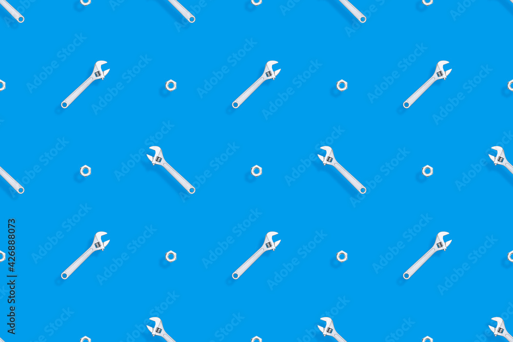 Adjustable metal wrench seamless pattern. Background from a metal wrench and nut. Adjustable metal wrench seamless pattern. Background from a metal wrench and nut.