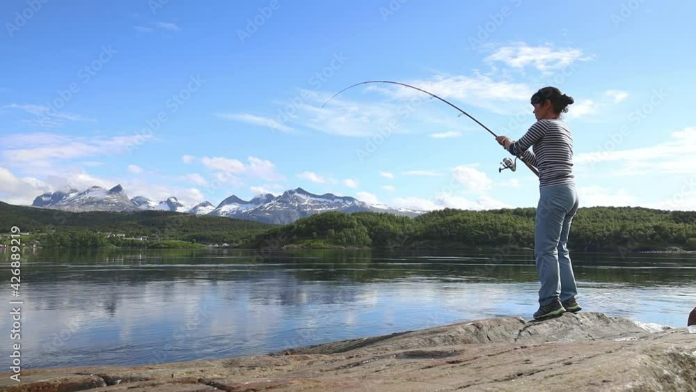 Woman fishing on Fishing rod spinning in Norway. Woman fishing on Fishing rod spinning in Norway.