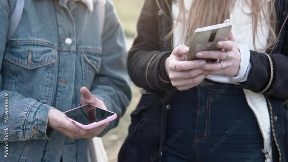 Women outdoors using their phone and sharing social media apps to stay connected Women outdoors using their phone and sharing social media apps to stay connected