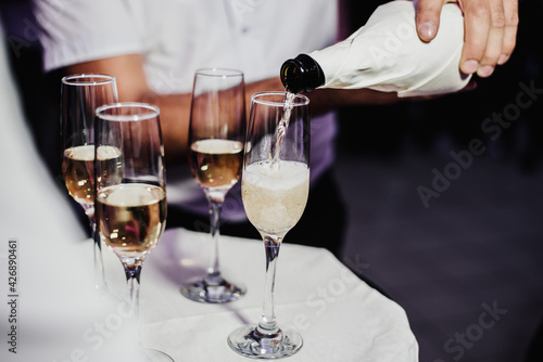 waiter pours champagne into the glasses
