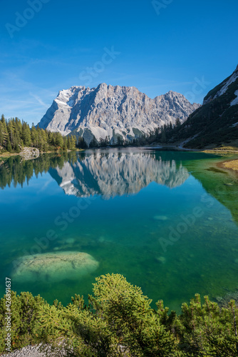 Zugspitze mountain reflecting in turquoise water of lake Seebensee, idyllic landscape Ehrwald tirol