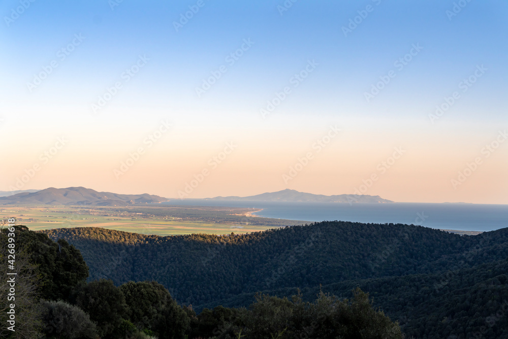 Italy, Tuscany, Tirli, panoramic view at the sunset of the Meremmana plain, the coastline up to the Uccellina mountains and the Monte Argentario, in the background the island of Giannutri.