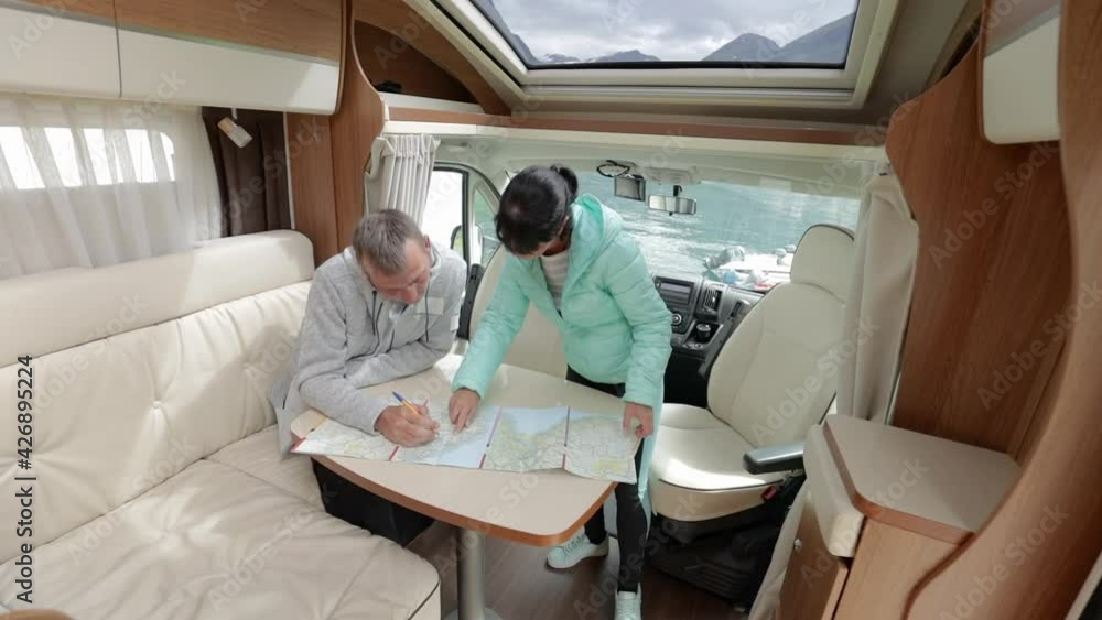 Couples in RV Camper looking at the local map for the trip. Couples in RV Camper looking at the local map for the trip.