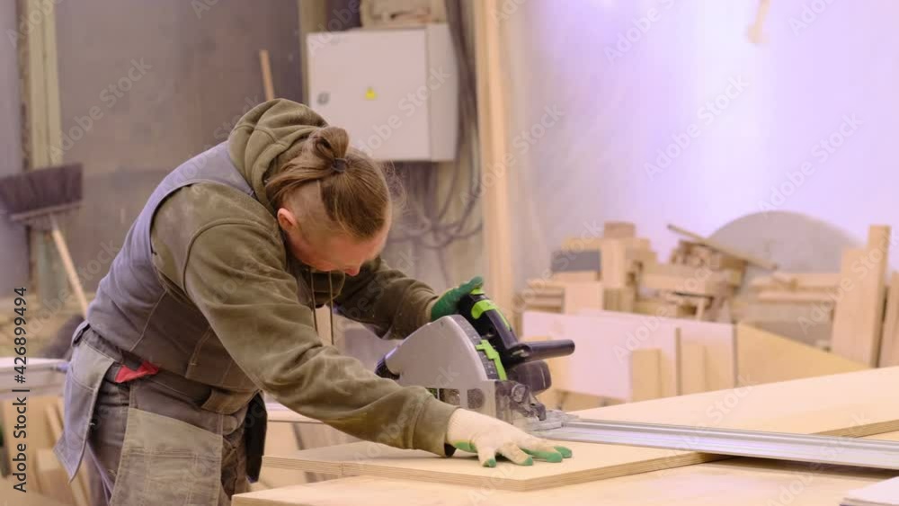 Close up. Carpenter at workshop polishes wooden board with a electric orbital sander. Woodwork and furniture making concept. Close up. Carpenter at workshop polishes wooden board with a electric orbital sander. Woodwork and furniture making concept.