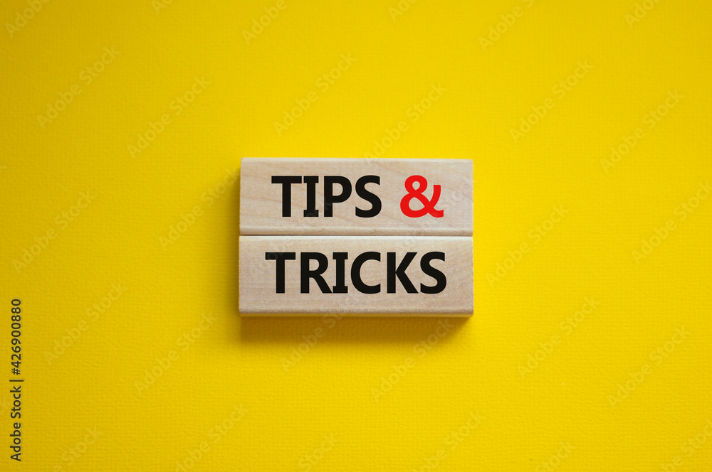 Tips and tricks symbol. Wooden blocks with words 'Tips and tricks'. Beautiful yellow background. Business, tips and tricks concept. Copy space. Tips and tricks symbol. Wooden blocks with words 'Tips and tricks'. Beautiful yellow background. Business, tips and tricks concept. Copy space.