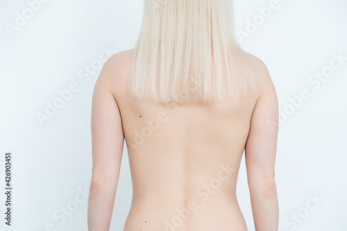 Young blond lady with a beautiful hair on gray background
