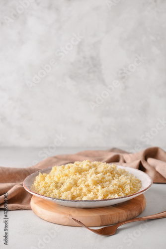 Plate with tasty couscous on table
