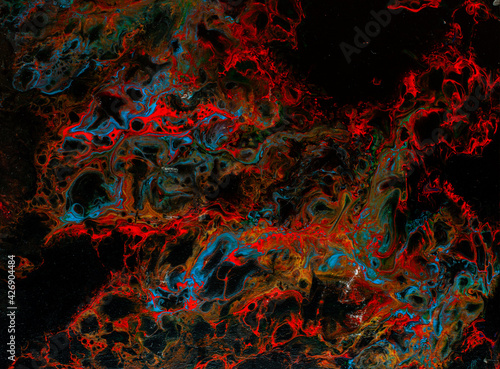 Texture in the style of fluid art. Abstract background with swirling paint effect. Liquid acrylic paint background. Black, blue and red colors.