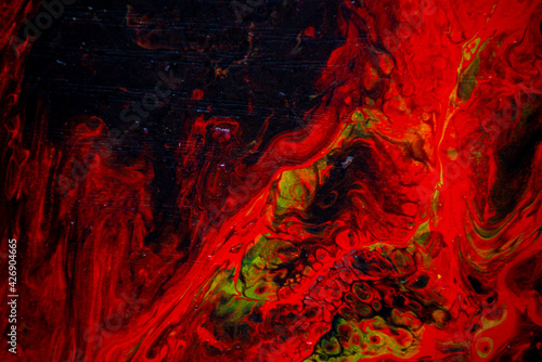 Texture in the style of fluid art. Abstract background with swirling paint effect. Liquid acrylic paint background. Red, black and yellow colors.