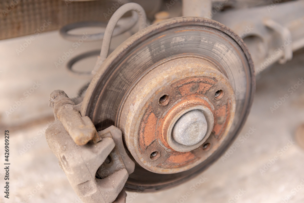 Heavily worn brake disc. Car brake disc after removing the wheel. A rusty disk that needs to be replaced. Heavily worn brake disc. Car brake disc after removing the wheel. A rusty disk that needs to be replaced.